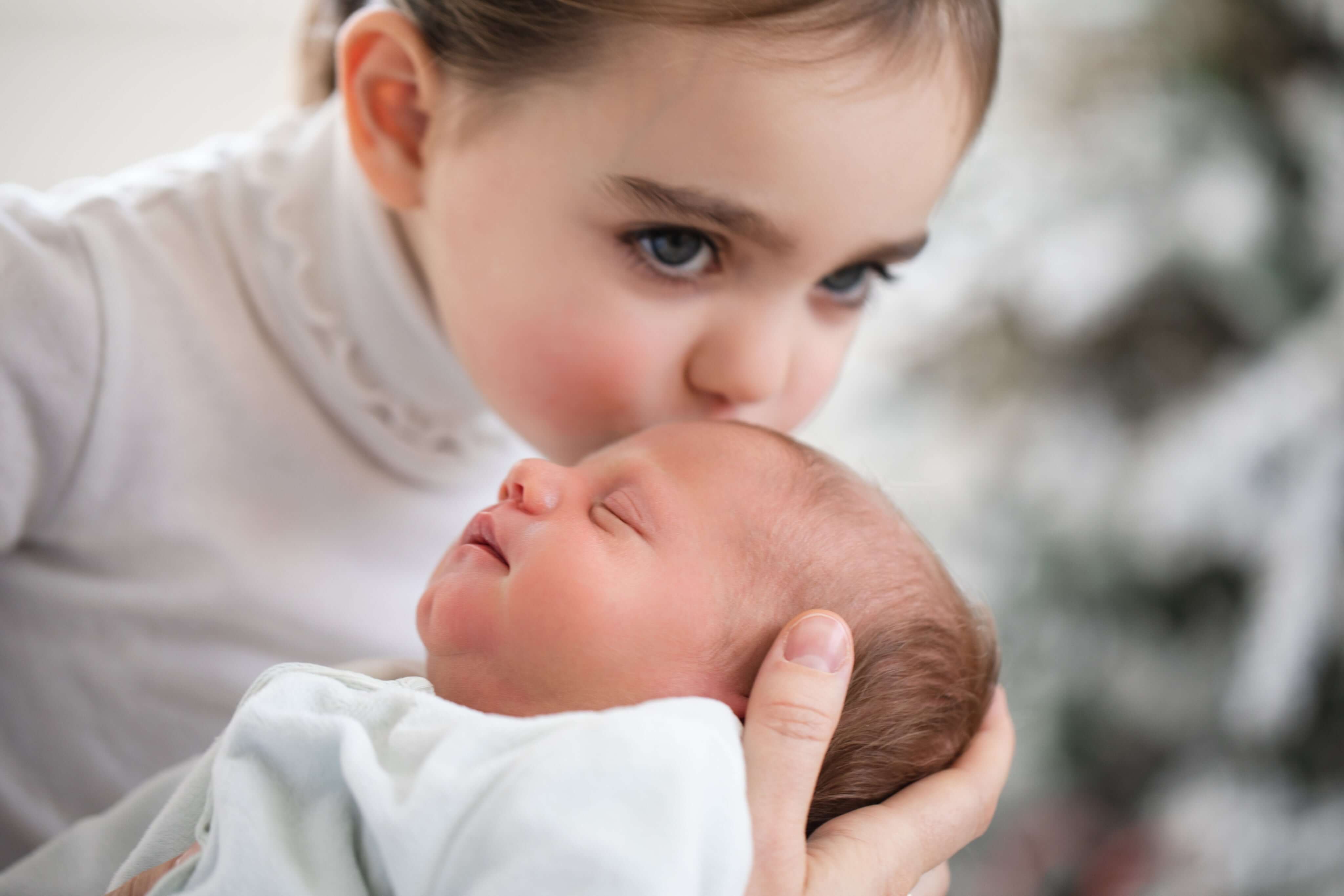 Honest Touch baby carriers and newborn essentials - Sister kissing baby