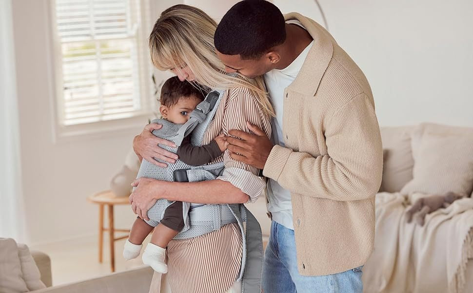 Family with a baby carrier indoors
